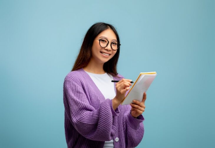 Student writing down a list of items she needs to take to university